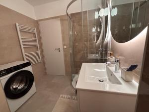 a bathroom with a sink and a washing machine at Penthouse-Villa Natura in Hegykő