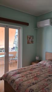 a bedroom with a bed and a sliding glass door at DaMa Blue in Saronida