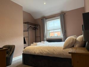 a bedroom with a large bed and a window at The Applewood Regency in Southwell