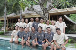 a group of men posing next to a swimming pool at D'Lagoon Dive Resort in Bitung