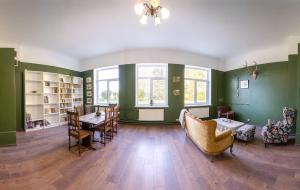 a room with green walls and a table and chairs at Bērzgala Viesu Nams in Stradi