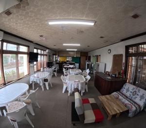 a dining room with tables and chairs and tablesktop at Adventure Hostel う島や in Iriomote