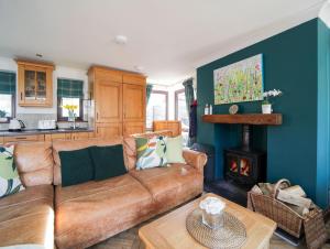 a living room with a couch and a stove at Sycamore in Penpillick