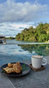 a plate of cookies and a cup of coffee on a table at D'Lagoon Dive Resort in Bitung
