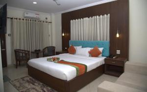 a bedroom with a large bed and a table at Gautam Buddha International Hotel Ltd in Gautam Buddha International Airport +6 photos