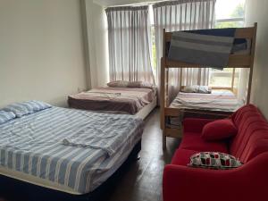 a bedroom with two bunk beds and a red couch at El Sol de Simbal in Trujillo +14 photos