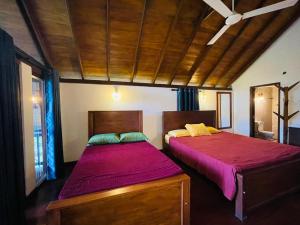 a bedroom with two beds and a wooden ceiling at Hasruk Eco Rest in Yatipauwa