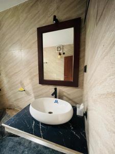 a bathroom with a sink and a mirror on a counter at Hasruk Eco Rest in Yatipauwa