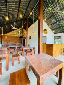 a dining room with wooden tables and benches at Hasruk Eco Rest in Yatipauwa