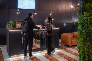 a man and a woman standing at a cash register at SERHS Carlit Boutique Hotel in Barcelona