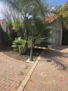 a lamp post sitting on a brick sidewalk next to a house at House 55D in Lichtenburg