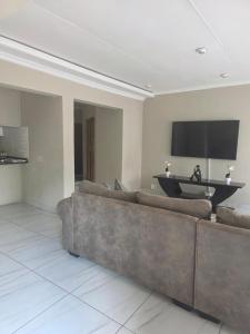 a living room with a couch and a flat screen tv at House 55D in Lichtenburg