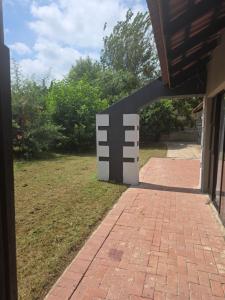 a brick walkway leading to a building with a sculpture at House 55D in Lichtenburg