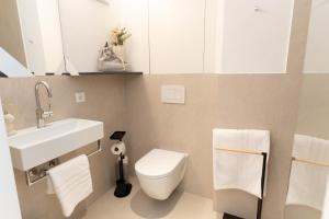 a bathroom with a white toilet and a sink at GansFein Suites in Wels +25 photos