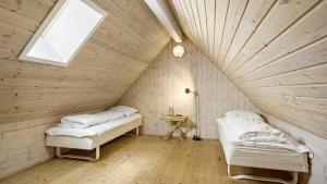 two beds in a room with a wooden ceiling at Villavilla 182 - Rømø, Sydjylland in Høm