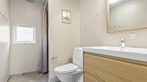 a bathroom with a sink and a toilet and a mirror at Villavilla 182 - Rømø, Sydjylland in Høm +15 photos