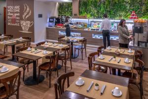 a restaurant with tables and people standing at a counter at SERHS Carlit Boutique Hotel in Barcelona