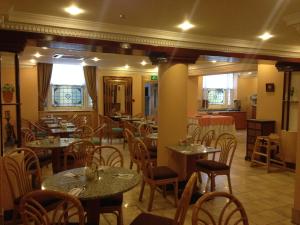 a restaurant with tables and chairs in a room at Troy Hotel in London