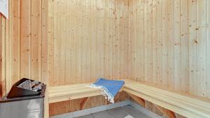 a wooden bench in a sauna with a trash can at Villavilla 247 - Ebeltoft, Østjylland in Ebeltoft