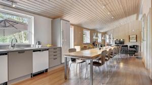 a kitchen with a wooden ceiling and a long table at Villavilla 247 - Ebeltoft, Østjylland in Ebeltoft