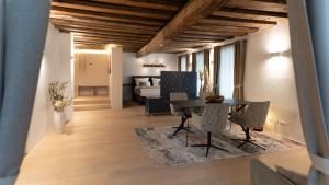a dining room and living room with a table and chairs at GansFein Suites in Wels
