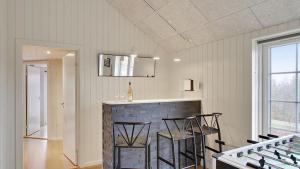a kitchen with a bar with stools in a room at Villavilla 386 - Ebeltoft, Østjylland in Ebeltoft