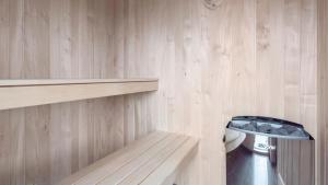 a bathroom with a toilet and a wooden wall at Villavilla 591 - Rømø, Sydjylland in Høm