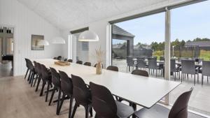 a dining room with a large white table and chairs at Villavilla 591 - Rømø, Sydjylland in Høm +16 photos