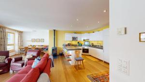 a living room with a red couch and a kitchen at Apartment Macun in Silvaplana