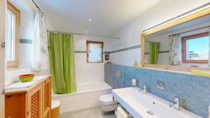 a bathroom with a tub and a sink and a toilet at Apartment Macun in Silvaplana +9 photos