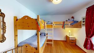 two bunk beds in a room with wooden floors at Apartment Macun in Silvaplana