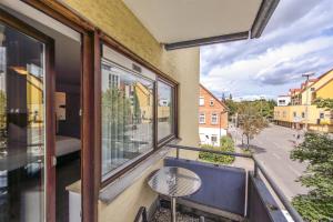 a balcony with a table and a view of a street at Ratshotel - City Aparthotel Aalen in Aalen
