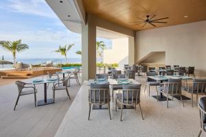 a restaurant with tables and chairs and a view of the ocean at LIME Resort Bohol, a member of Radisson Individuals Premier in Panglao Island