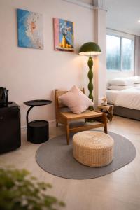 a living room with a bed and a chair and a table at R4R RoomforRest Boutique Hotel Bangsaen Beach in Ban Laem Thaen