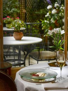 a table with a plate of food and a glass of wine at Relais & Châteaux Hotel Orfila in Madrid