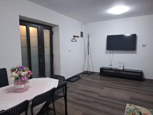 a living room with a table and a flat screen tv at Park Residence in Hoghiz