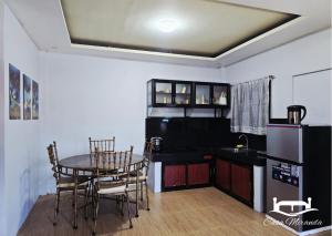a kitchen with a table and chairs and a refrigerator at Daet Homestay in Daet
