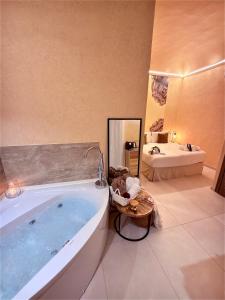 a bathroom with a large tub and a sink at Bìfara Rooms in Palermo +36 photos