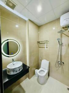 a bathroom with a toilet and a sink and a mirror at Amazon Hotel in Phước Hậu (1)