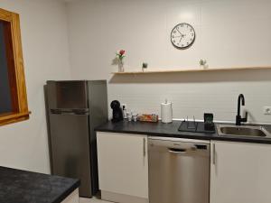 a kitchen with a refrigerator and a clock on the wall at The New House in Tabernas