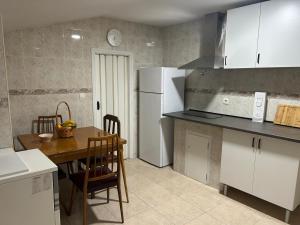 a kitchen with a table and a white refrigerator at Casa Marisol in Arrabal de Portillo