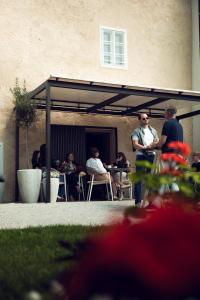 a group of people sitting at tables in a patio at GansFein Suites in Wels