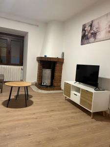 a living room with a tv and a table and a fireplace at Casa Marisol in Arrabal de Portillo