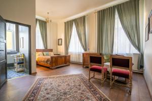 a bedroom with a bed and a desk and a table at Bērzgala Viesu Nams in Stradi