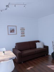a living room with a brown couch and a table at Appartement Margarethen in Vipiteno
