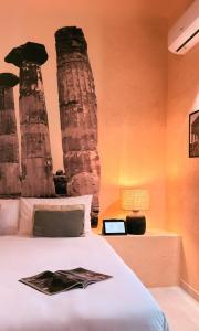 a bedroom with a bed with columns in the background at Bìfara Rooms in Palermo