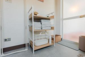 a small closet with white shelves and towels at Shirarutoro Villa in Shibecha
