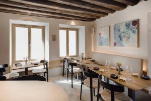 a restaurant with wooden tables and chairs and windows at GansFein Suites in Wels