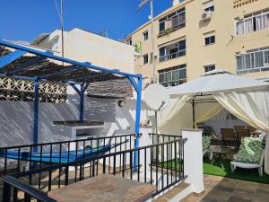 a balcony with a table and an umbrella at CitySun in Málaga