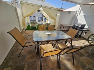 a table and chairs on a patio with a grill at CitySun in Málaga